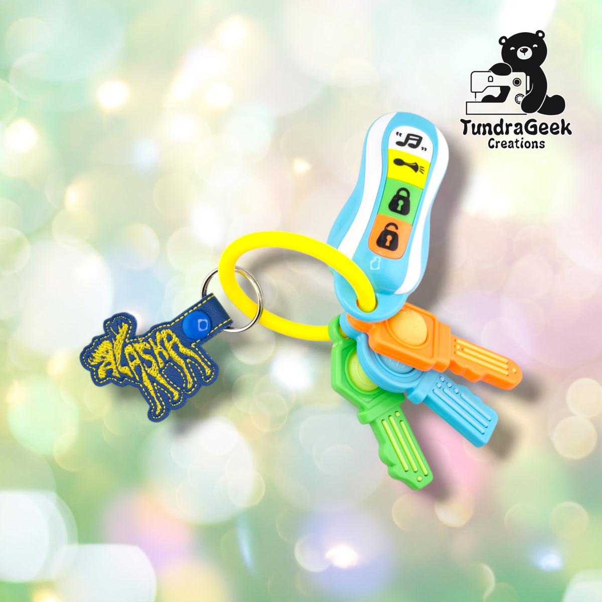 Alaskan Moose keychain attached to a set of colorful toy keys, showing the keychain in use on a ring alongside other charms.