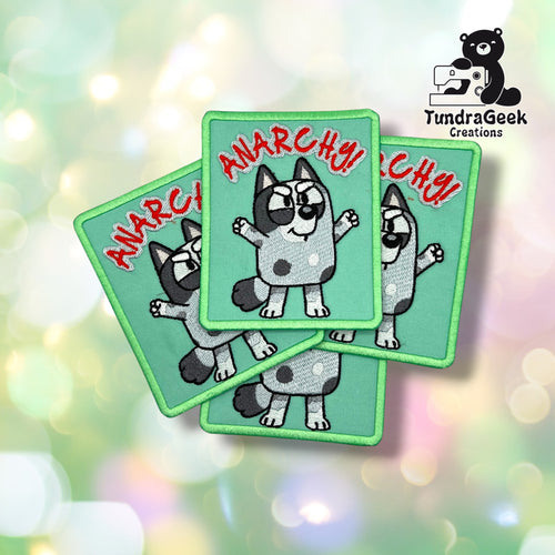 Three Anarchy Dog patches fanned out together, each showing the same spotted puppy design with raised paws and red "ANARCHY!" lettering on a teal background.