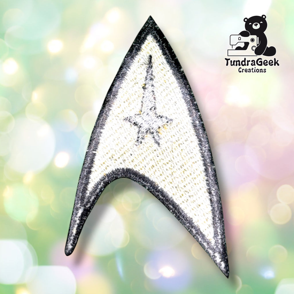 The backing of the arrowhead-shaped patch, showing embroidery texture from the reverse side.