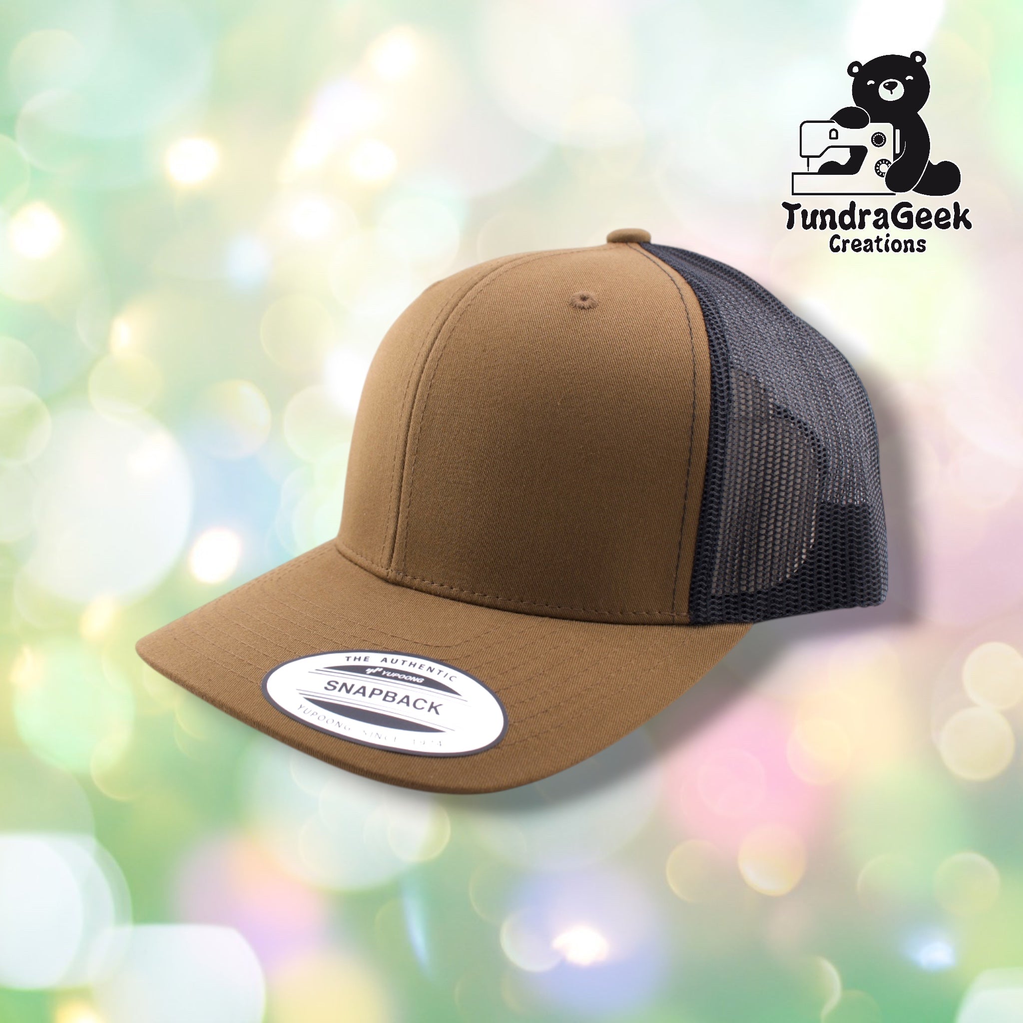 A tan and black mesh trucker snapback hat with white "Snapback" label visible on the front, displayed against a soft bokeh background.