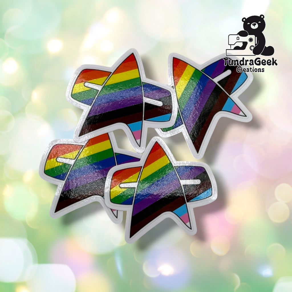 Four matching delta badge stickers overlapping in a cluster, all sharing identical Progress Pride striping and white outline.