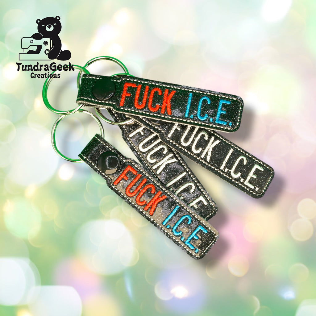 Three black keychains with embroidered text FUCK I.C.E. in red, white, and blue thread, displayed on a light, bokeh-style background with the TundraGeek Creations logo.