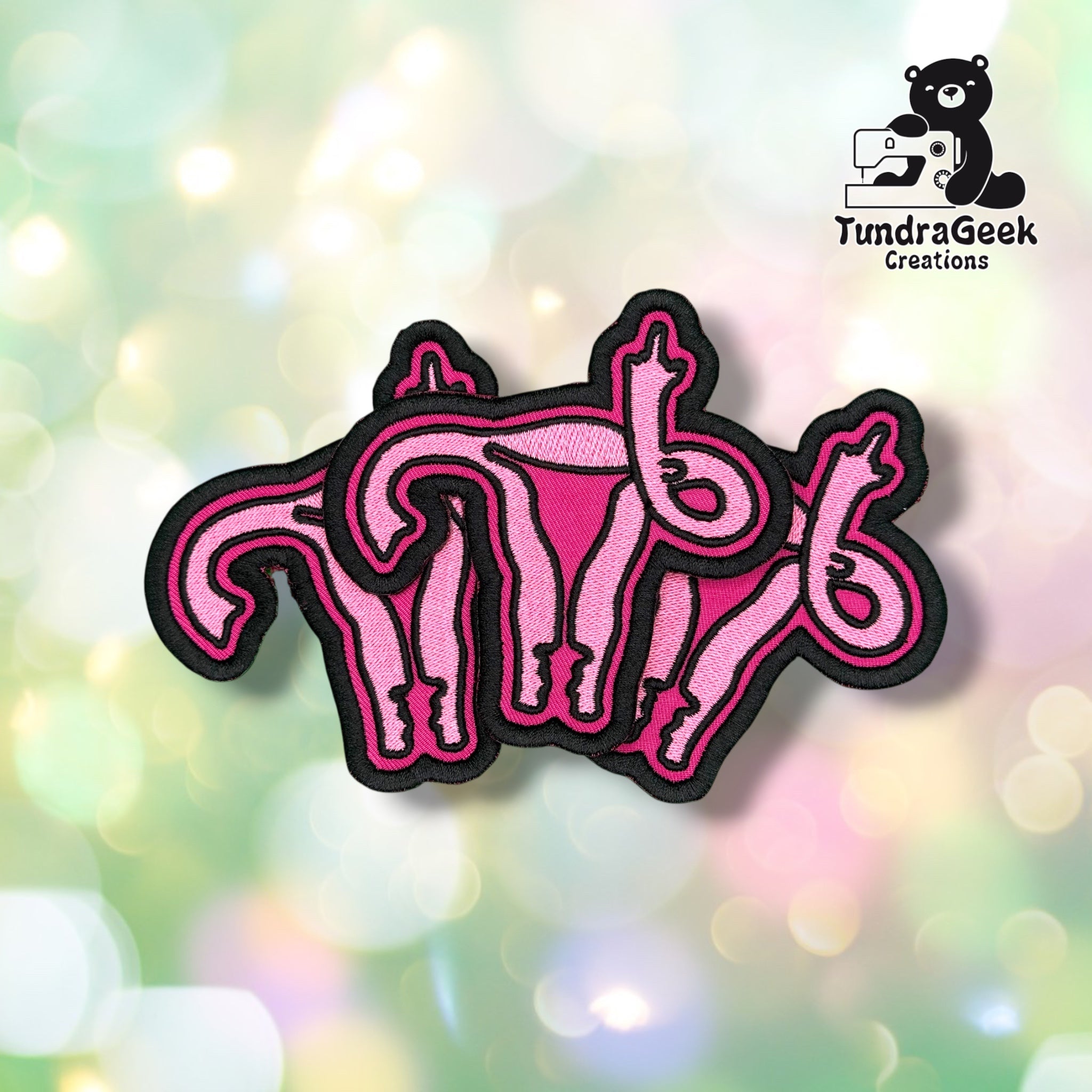 Three F Uterus patches fanned out together, each showing the same pink uterus-and-middle-finger design outlined in black.