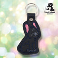 Front of a black faux leather French Bulldog keychain. An embroidered French Bulldog sits upright on a black vinyl base with pink inner ear accents, navy outline stitching, and gray facial detail stitching capturing the breed's characteristic wrinkles and expression. A gunmetal 9mm metal rivet closure is visible on the tab, with a silver split ring above.