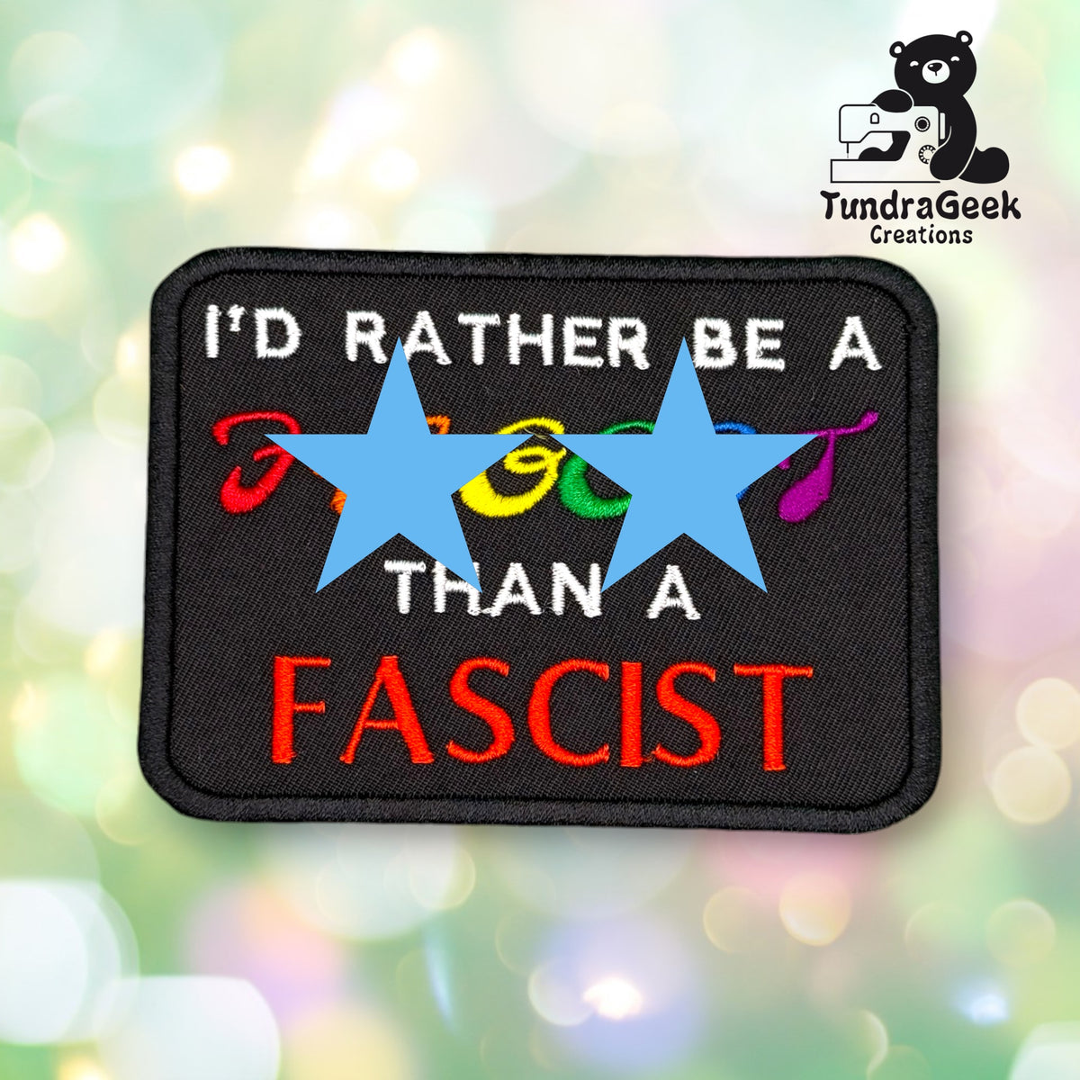 Front view of the patch with two blue stars covering the reclaimed slur in the design, for use on platforms or in contexts where the uncensored text isn't appropriate. The visible text reads "I'D RATHER BE A [covered] THAN A" in white, with "FASCIST" in bold red below.