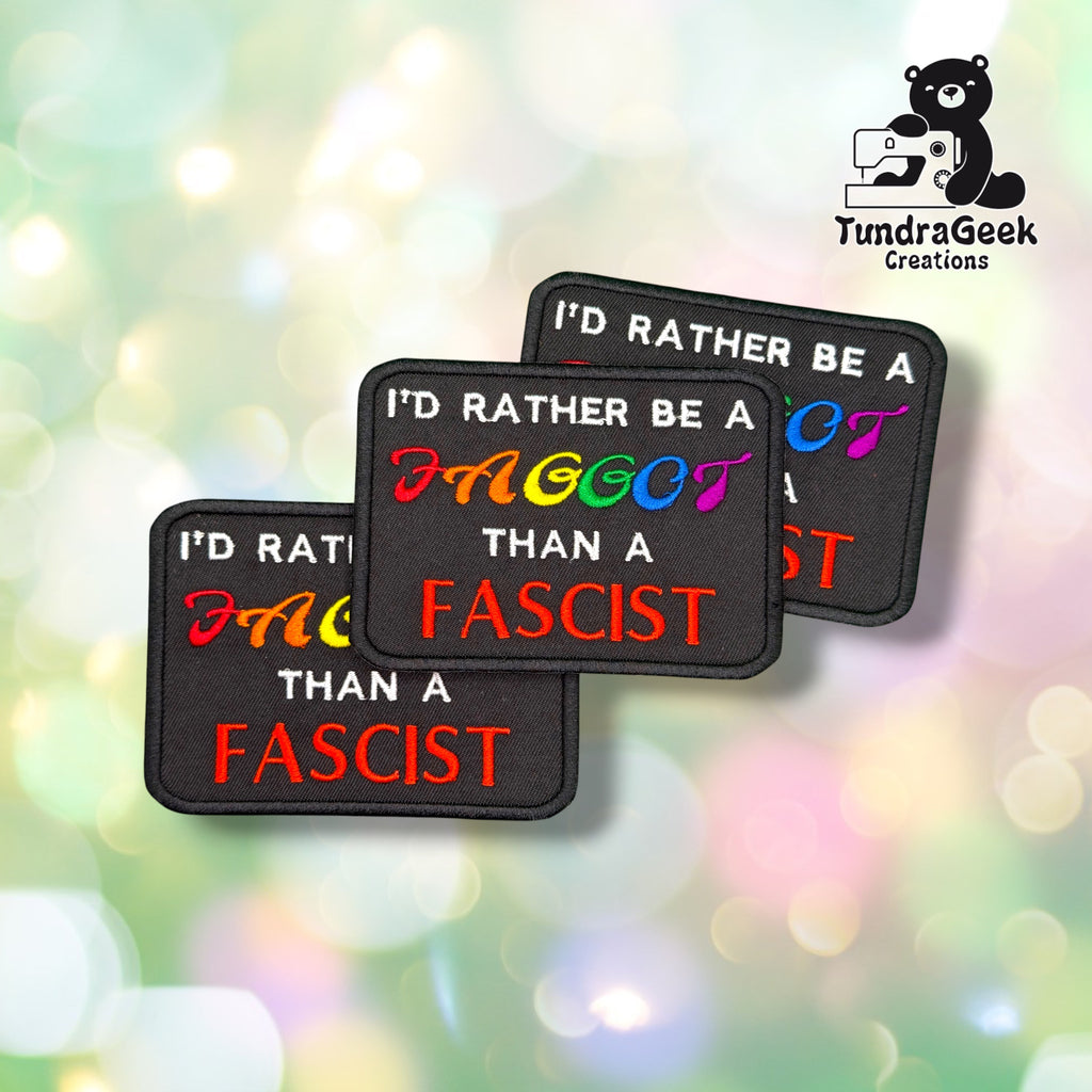 Three F than F patches fanned out together, each showing the same rainbow-lettered slogan on a black background.