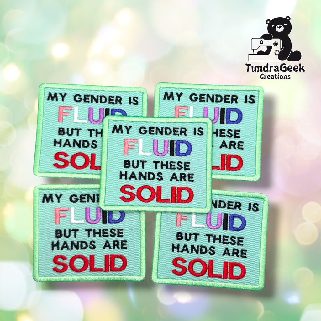 Five Gender Fluid Hands Solid patches fanned out together, each showing the same mint green background with the "FLUID" text in genderfluid flag colors and "SOLID" in red.