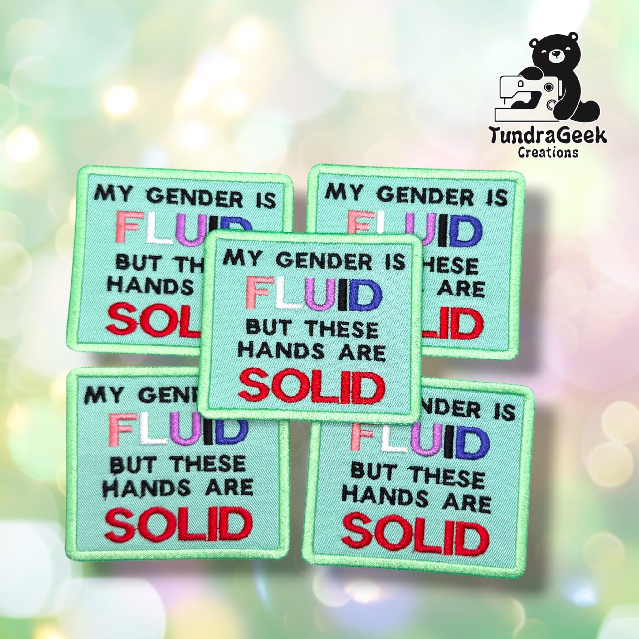 Five Gender Fluid Hands Solid patches fanned out together, each showing the same mint green background with the "FLUID" text in genderfluid flag colors and "SOLID" in red.