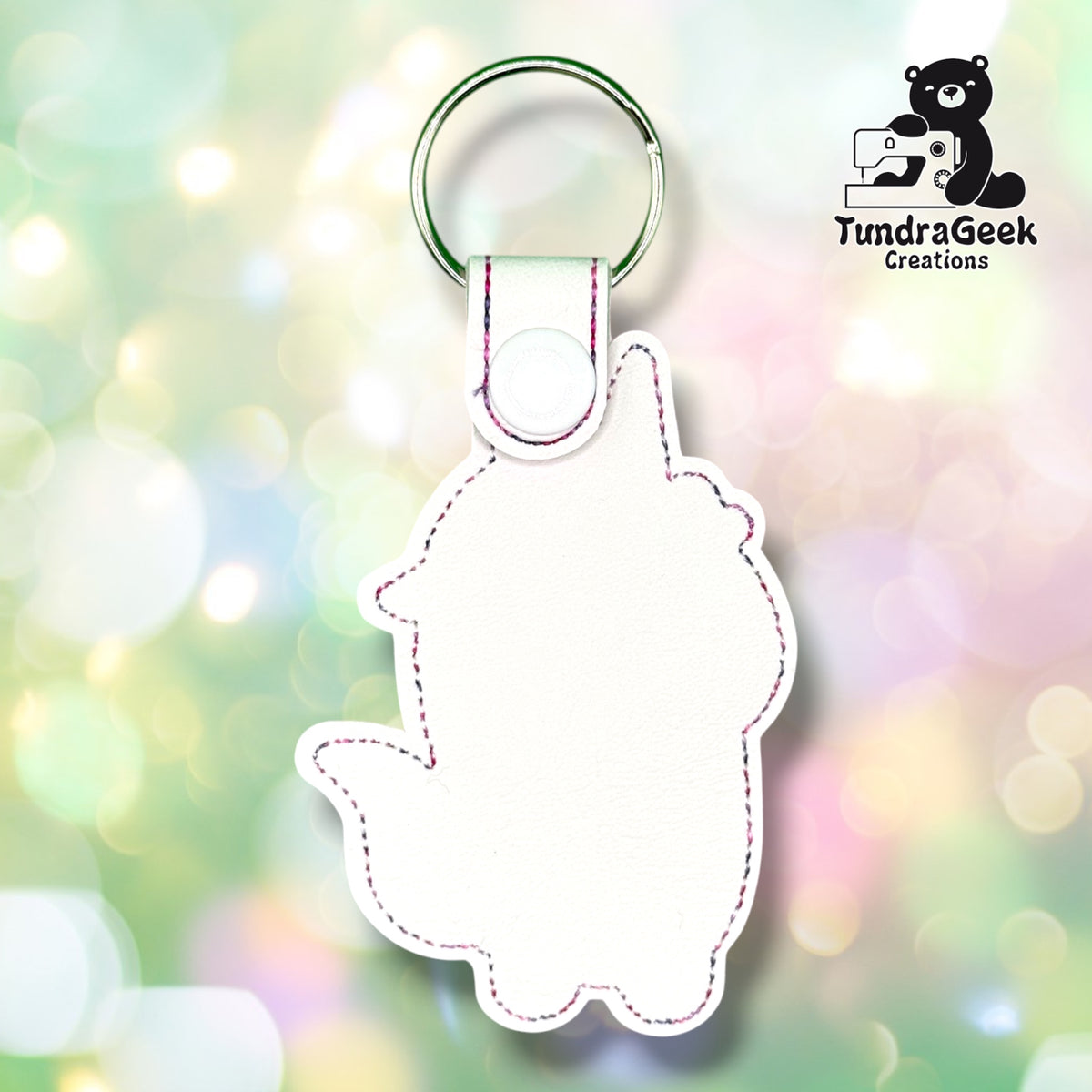 Back view of the keychain showing the plain white vinyl backing in the unicorn-head-and-body outline shape, with pink and purple stitched edge detailing, a white plastic snap closure, and a green split ring. No embroidery visible from this side — this is a detail/back shot of the same item, not a separate colorway.