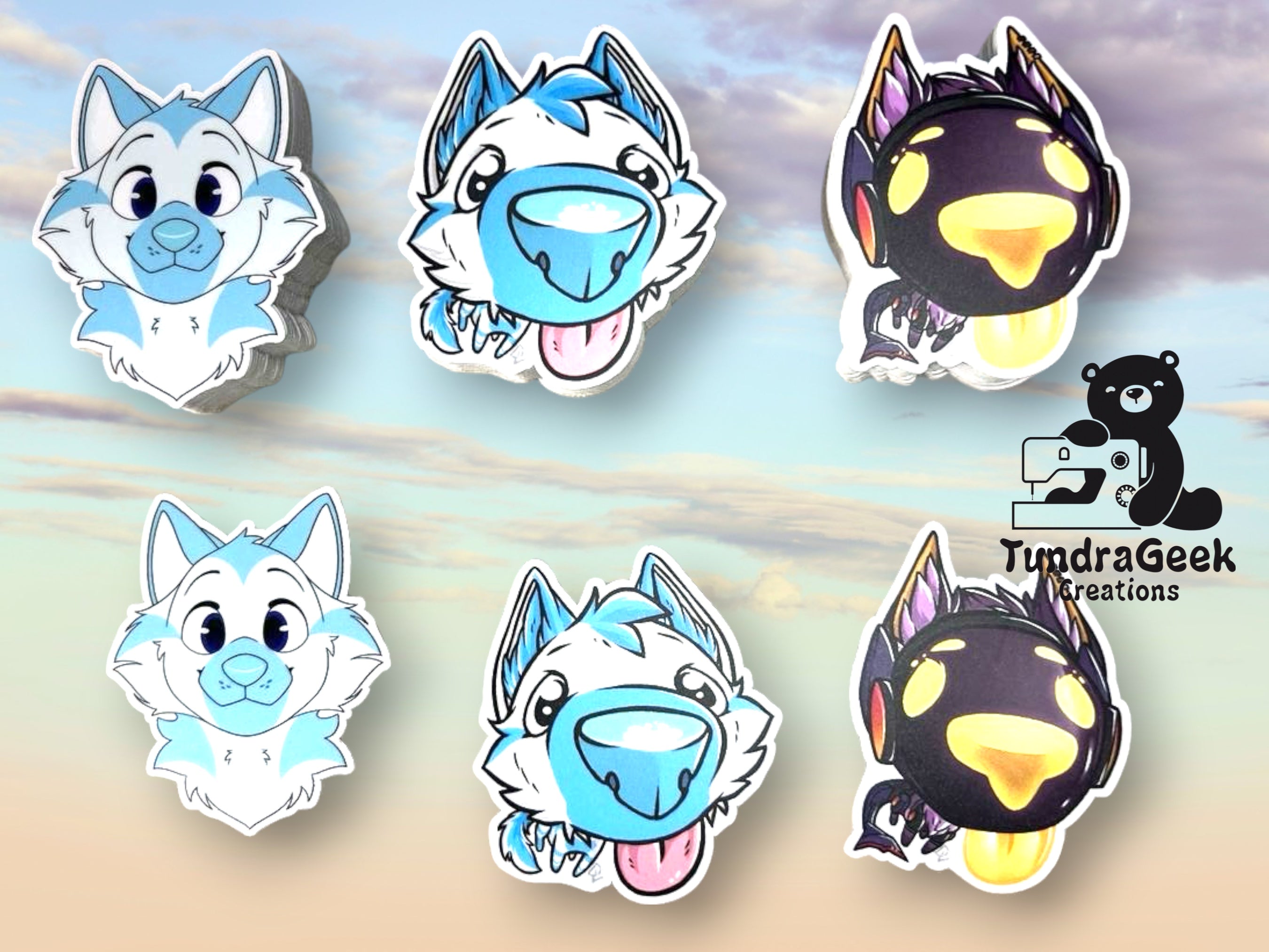 Six die-cut sticker designs featuring cartoon furred animal faces are arranged on a soft pastel sky background. The designs include light blue and white wolf/fox heads and black/yellow/orange creature heads.