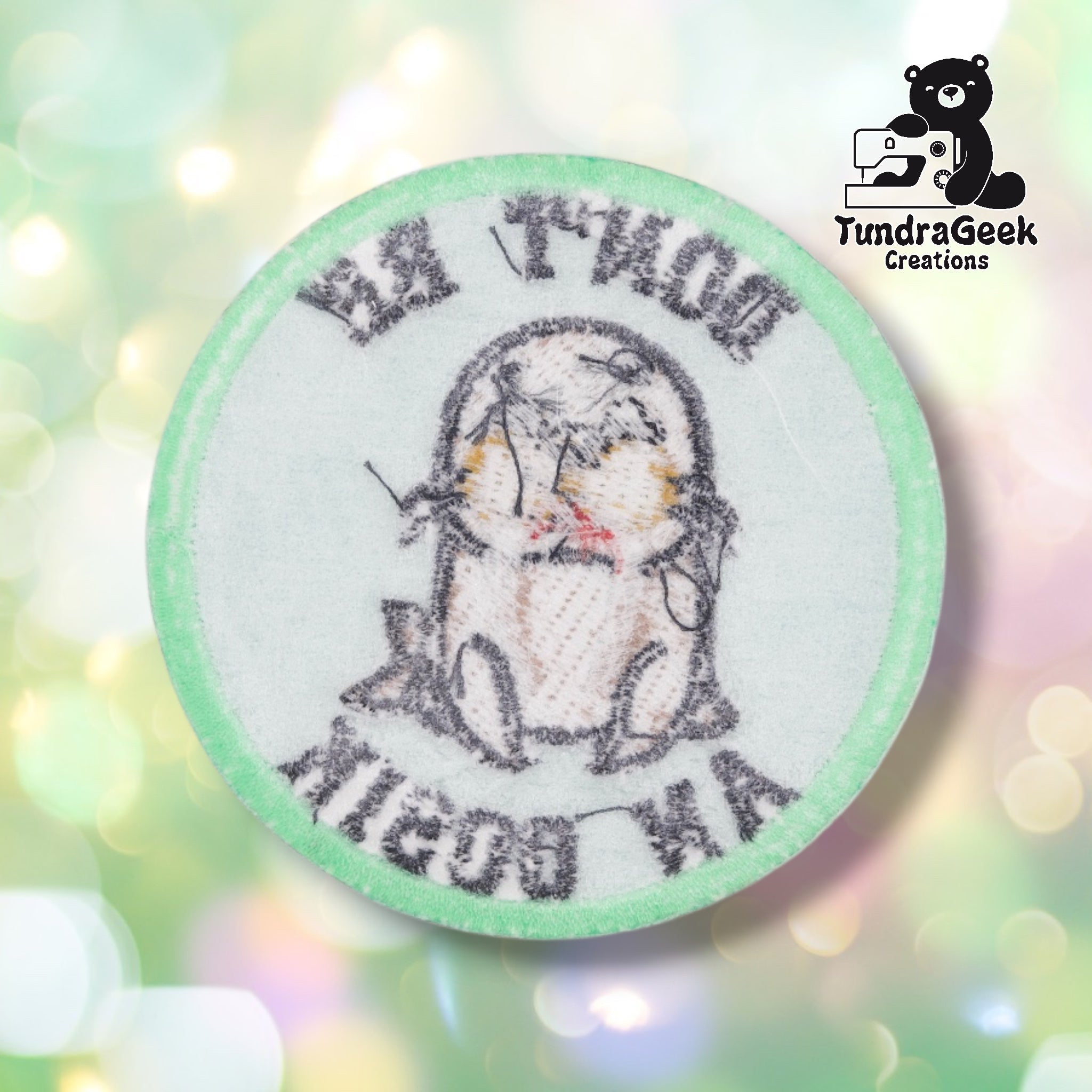 The reverse side of the patch, showing the embroidery stitch texture and mirrored outline of the walrus design and lettering from behind, along with the iron-on adhesive backing film.