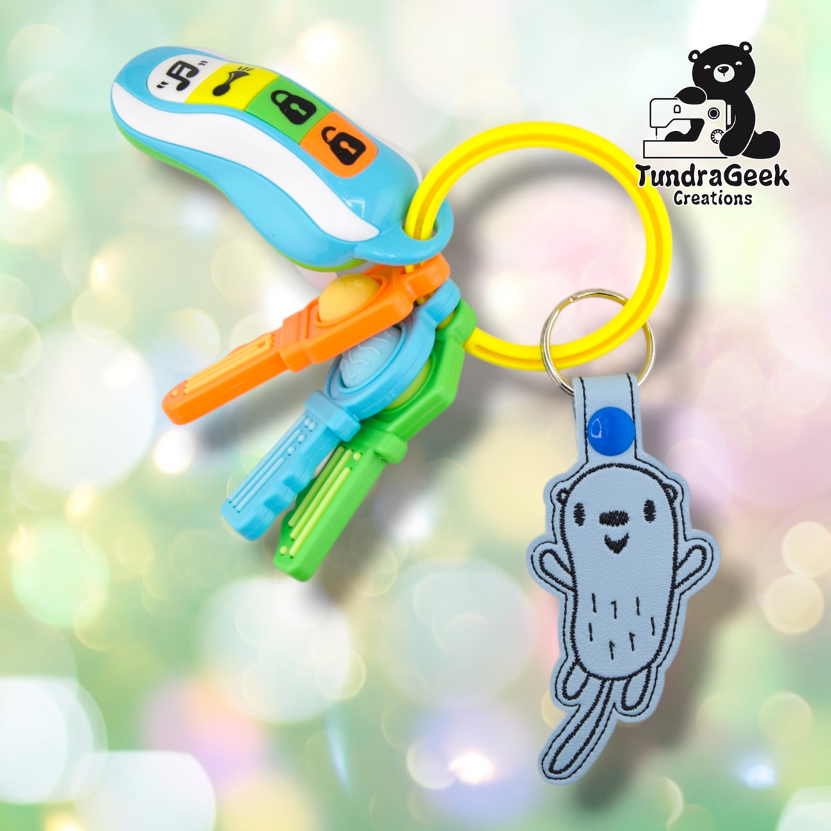 Otter keychain attached to a set of colorful toy keys, showing the keychain in use on a ring alongside other charms.