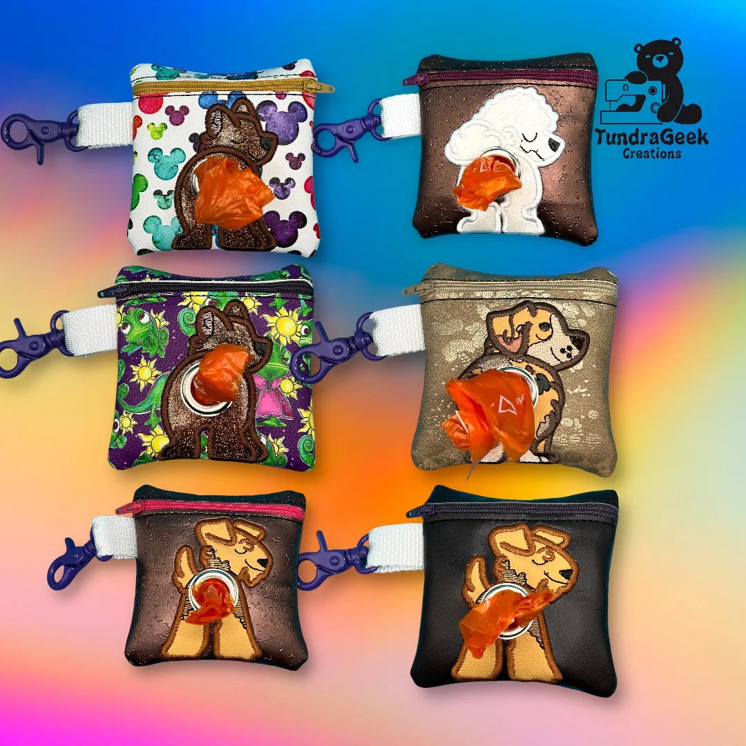 Six small zippered pouches with different dog designs, each holding an orange waste bag, displayed against a colorful gradient background. Logo TundraGeek Creations in the top right corner.