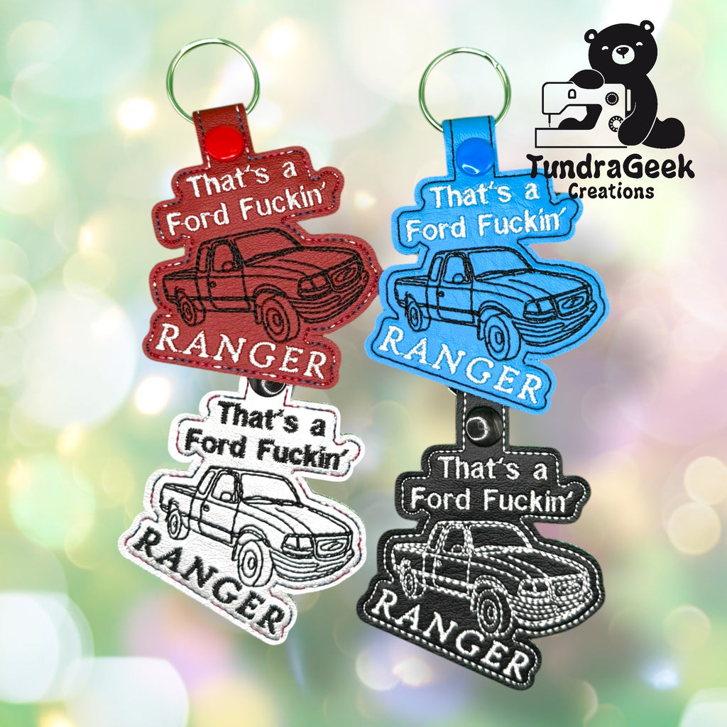 Four keychains shaped like trucks with the text Thats a Ford Fuckin Ranger in various colors, displayed on a blurred green background with the TundraGeek Creations logo.