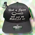 A black baseball cap with white embroidered text reading Grab a Spoon and eat my WHOLE ass and an image of a spoon above the text.