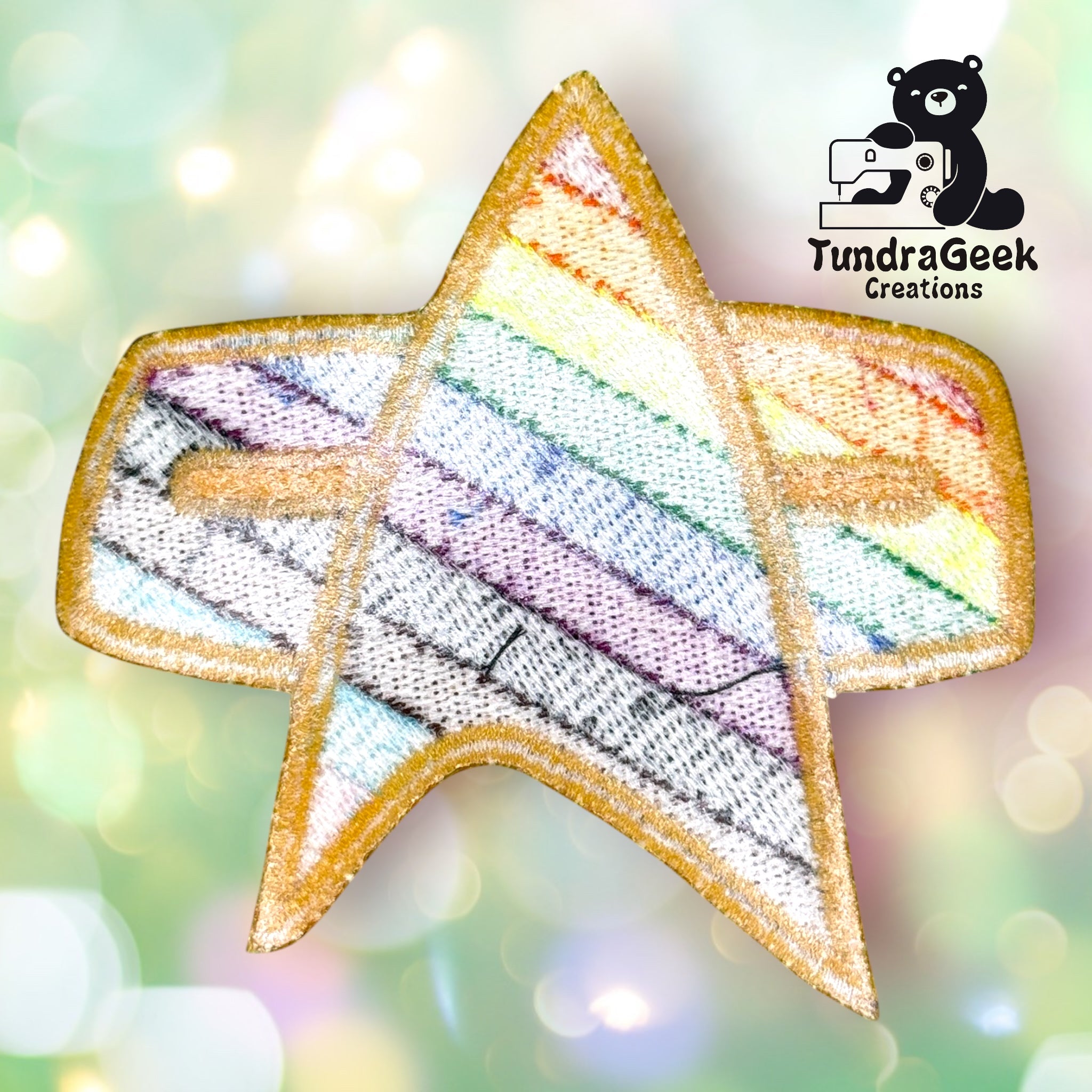 A patch shaped like a Star Trek insignia, featuring diagonal rainbow stripes, is shown with the TundraGeek Creations logo in the top right corner.