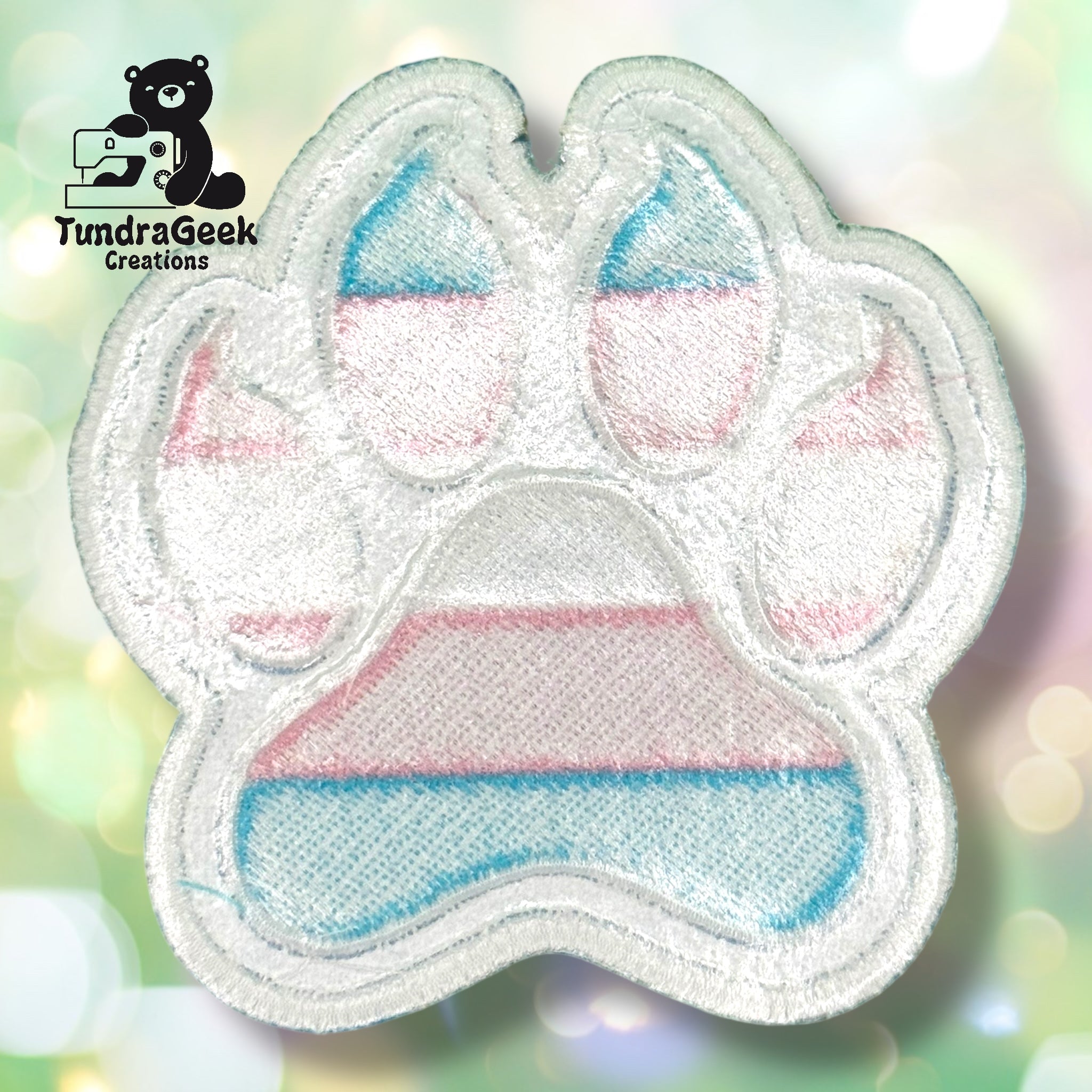 The reverse side of an embroidered paw-shaped patch, showing the iron-on adhesive backing. The paw shape, size, and construction shown here are consistent across all flag variants in this listing.