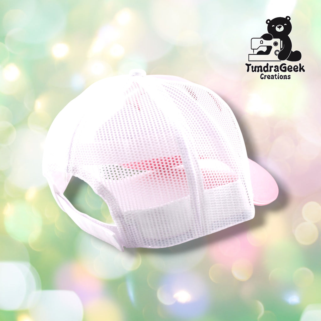 A white mesh baseball cap with pink bill displayed against a soft, blurred pastel background.