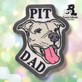 Grey embroidered patch with a black merrowed edge, showing a smiling full-eared pitbull with its tongue out. "PIT" is stitched above the dog's head and "DAD" below, both in black block lettering.