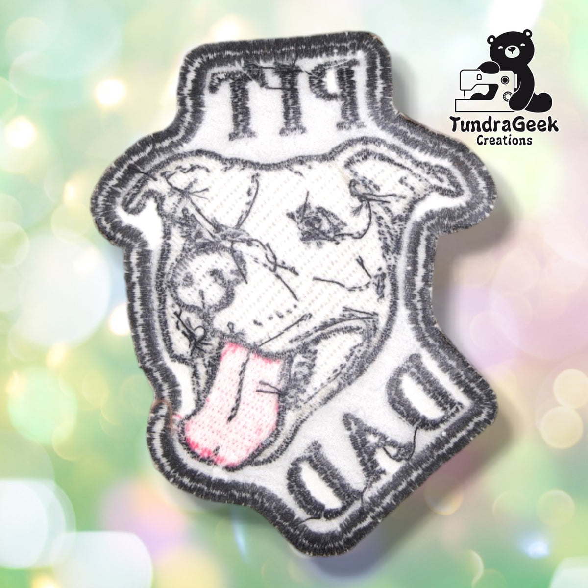 The back of the Pit Dad patch, showing the light iron-on adhesive backing used to hold the patch in place before sewing.