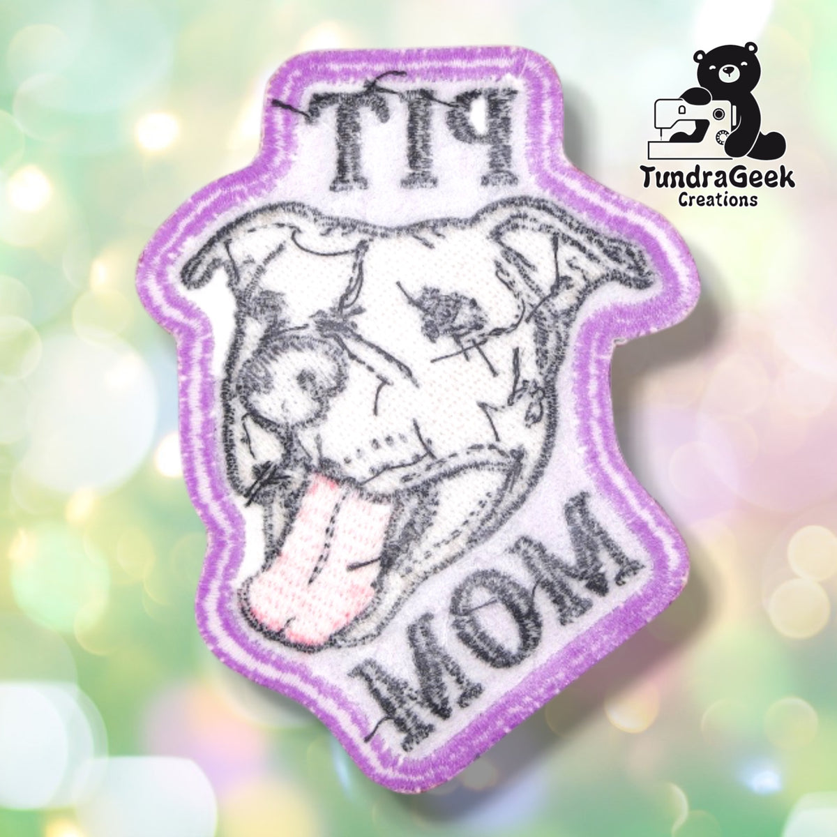 The back of the Pit Mom patch, showing the light iron-on adhesive backing used to hold the patch in place before sewing.