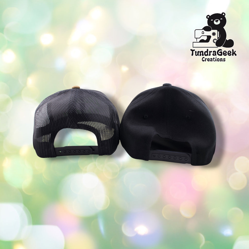 Two black baseball caps displayed back-to-back, one with mesh panels and one solid, with adjustable snap closures against a soft bokeh background.