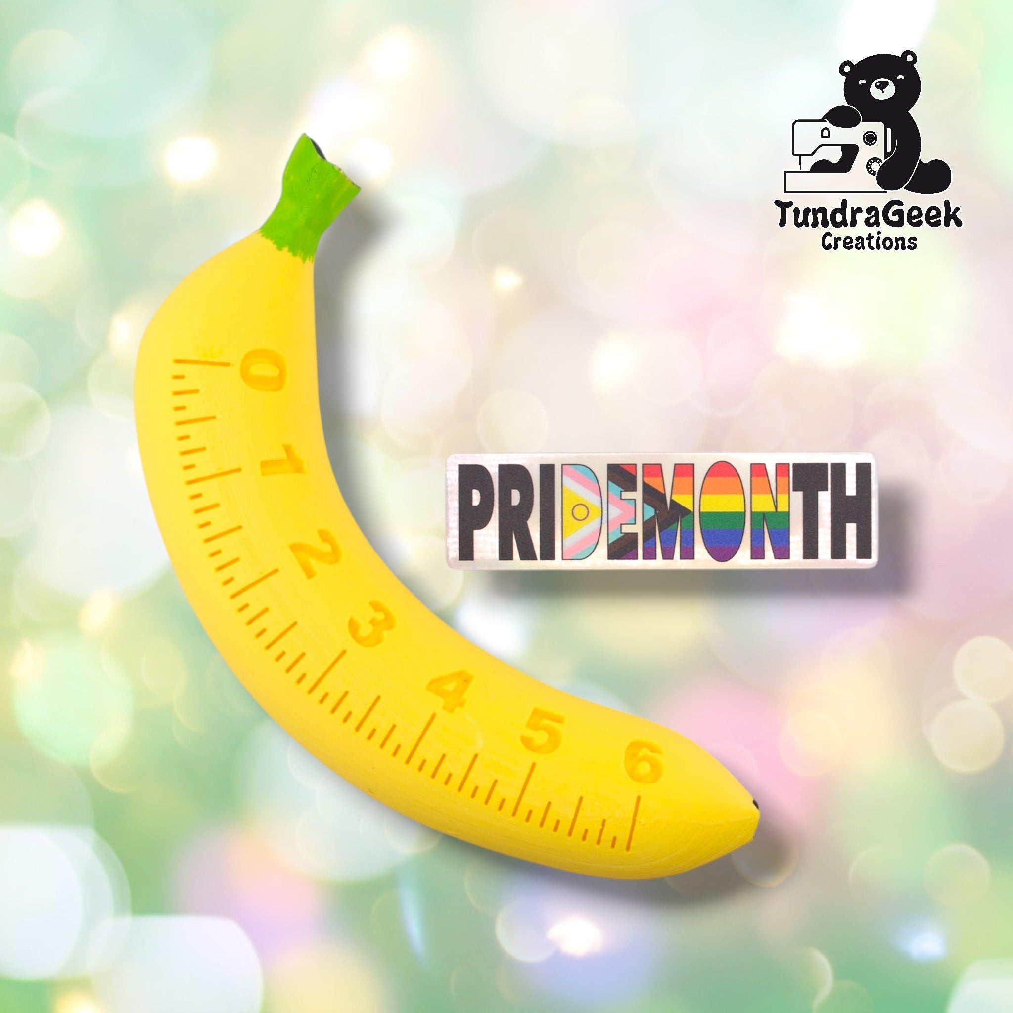 Pride Month holographic sticker shown next to the Imperial Scaling Banana, TundraGeek Creations' proprietary novelty ruler prop. Sticker measures approximately 4 inches wide by 1.1 inches tall.