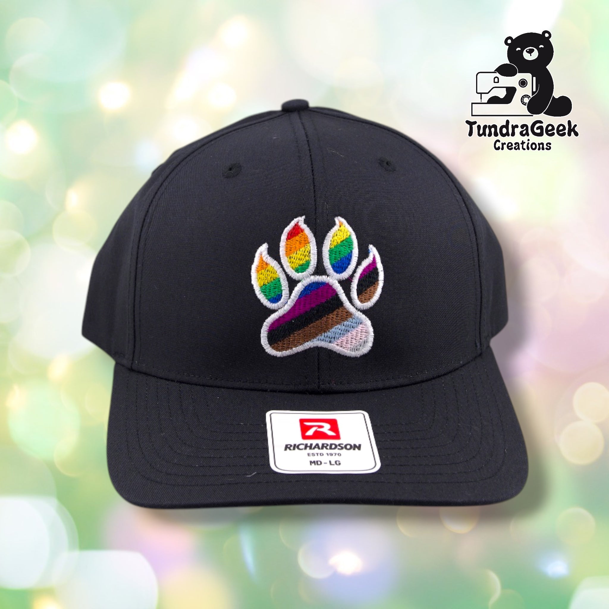 A black Richardson baseball cap with an embroidered rainbow paw print design and white Richardson brand label on the front.