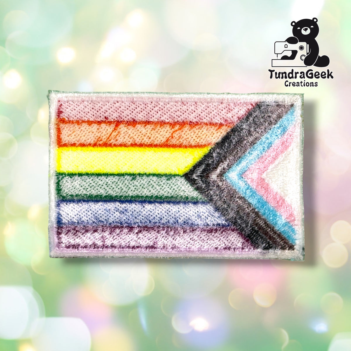 Back of the patch showing the reverse side of the embroidery in muted, softened colors, with the chevron and stripe pattern faintly visible through the backing fabric.