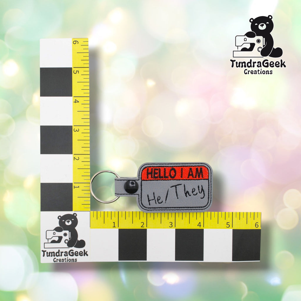 Keychain measured against a tailor's ruler, confirming approximately 4.25in wide by 2.75in tall including hardware.