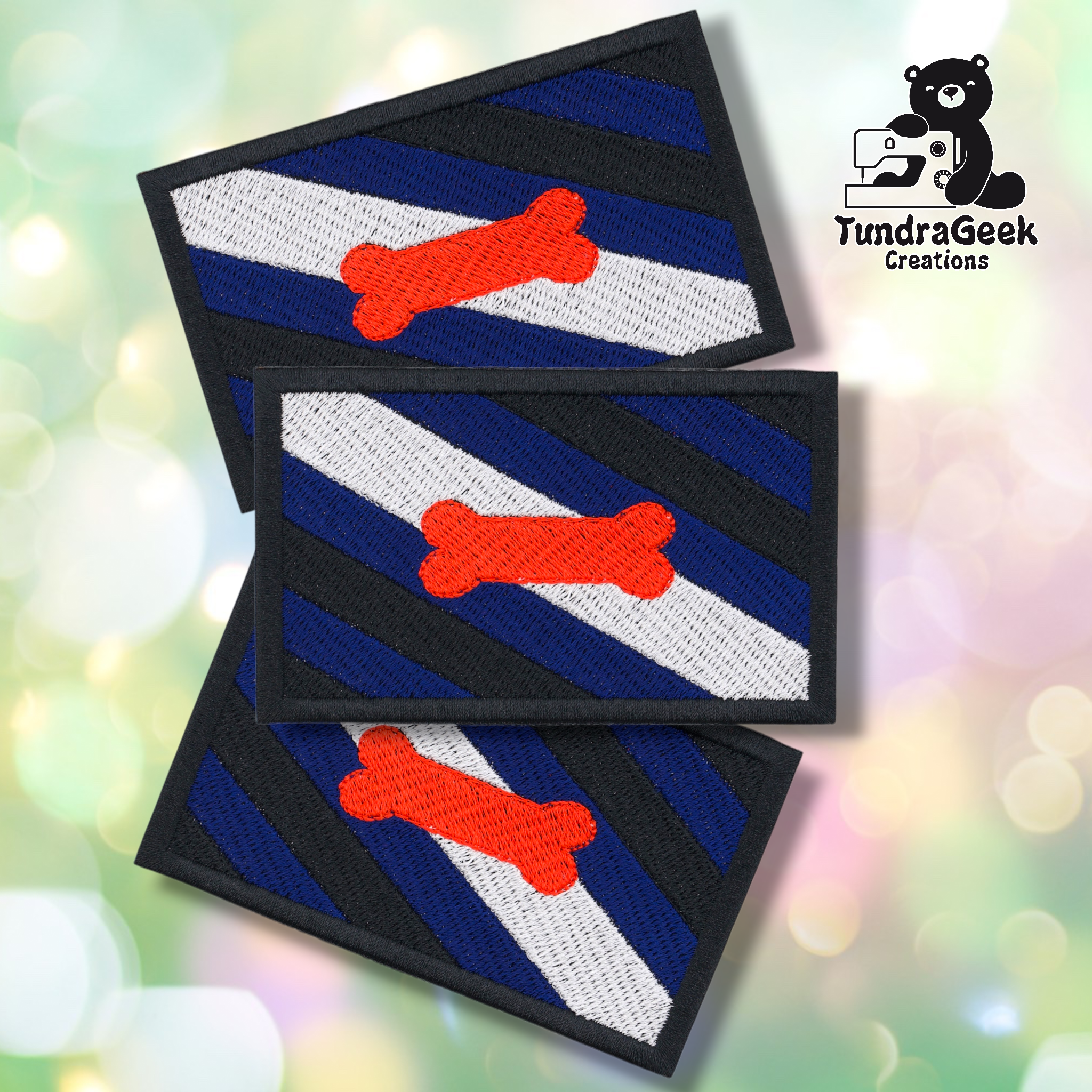 Three rectangular Pup Pride Flag Patches with blue, black, white, and gray diagonal stripes and a red bone in the center overlap. The TundraGeek Creations logo is in the top right. Embroidered sew-on patch with iron-on backing.
