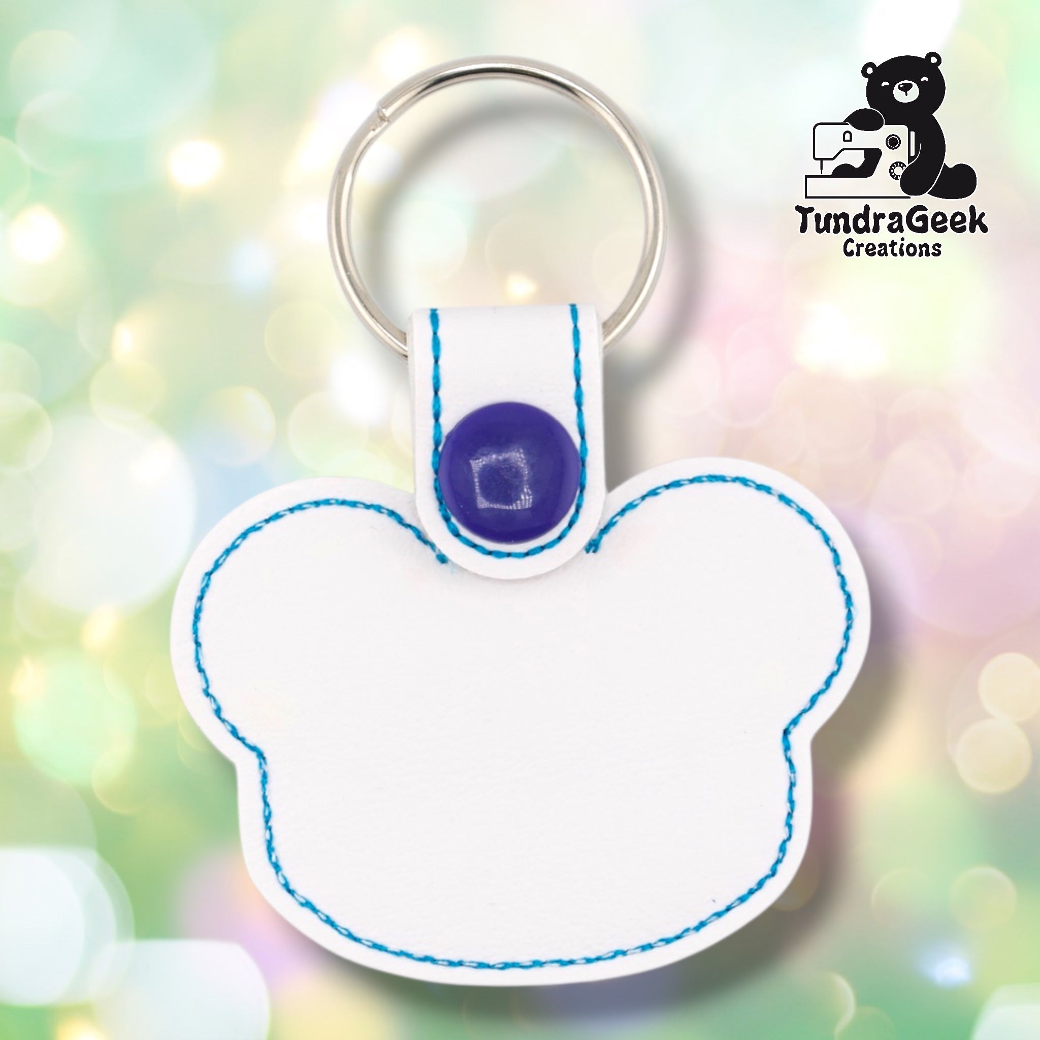 Plain back of the white panda keychain showing bright white faux leather and teal outline stitching following the panda head shape. Purple snap closure at top. No embroidery on reverse.