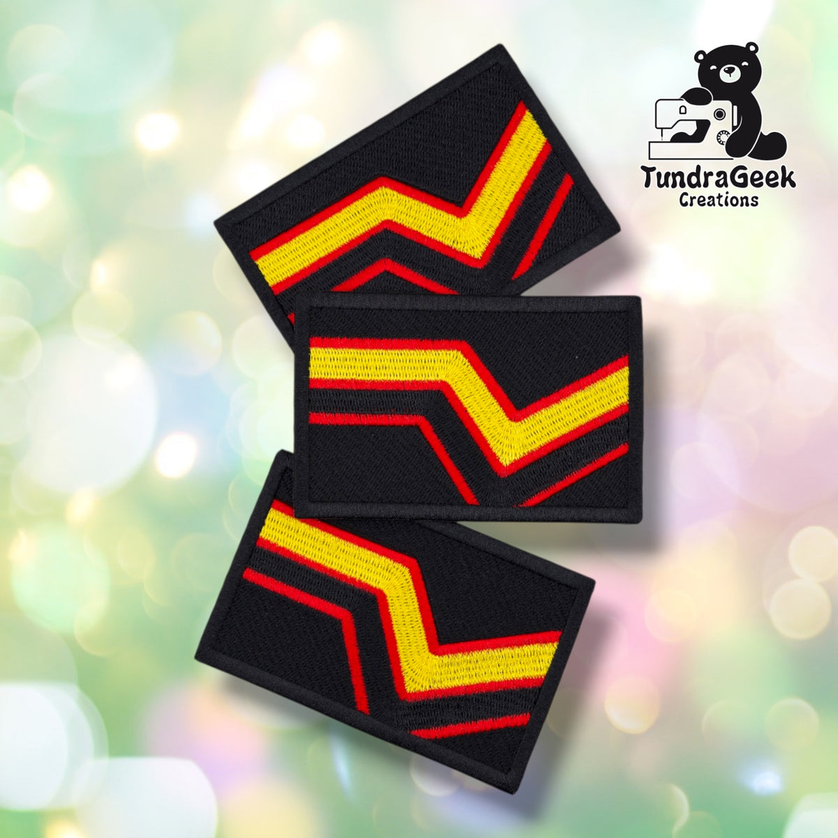 Three identical Rubber Pride Flag patches fanned out at different angles, each black with the same yellow and red chevron design.