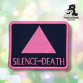 Front view of the rectangular variant: a black patch with a pink merrowed edge, embroidered with a solid pink triangle above "SILENCE=DEATH" in pink block lettering.