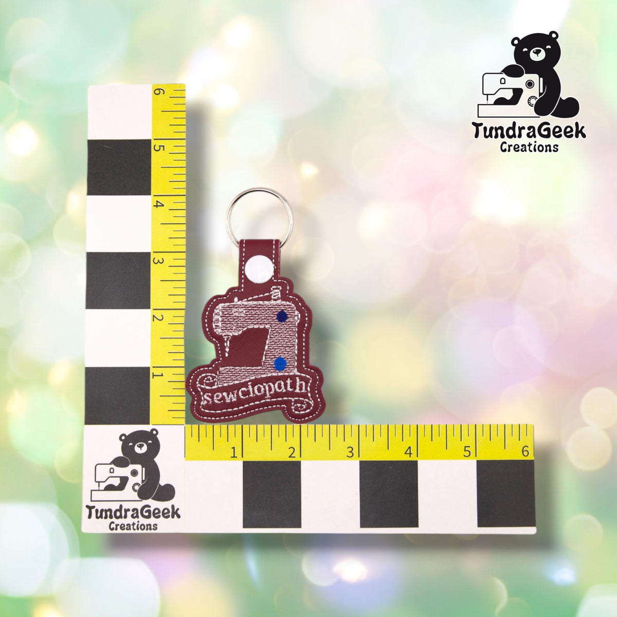 The keychain photographed against a yellow ruler marked in inches along both edges, for size reference. It measures 4.25 inches tall by 2.5 inches wide including hardware.  ---