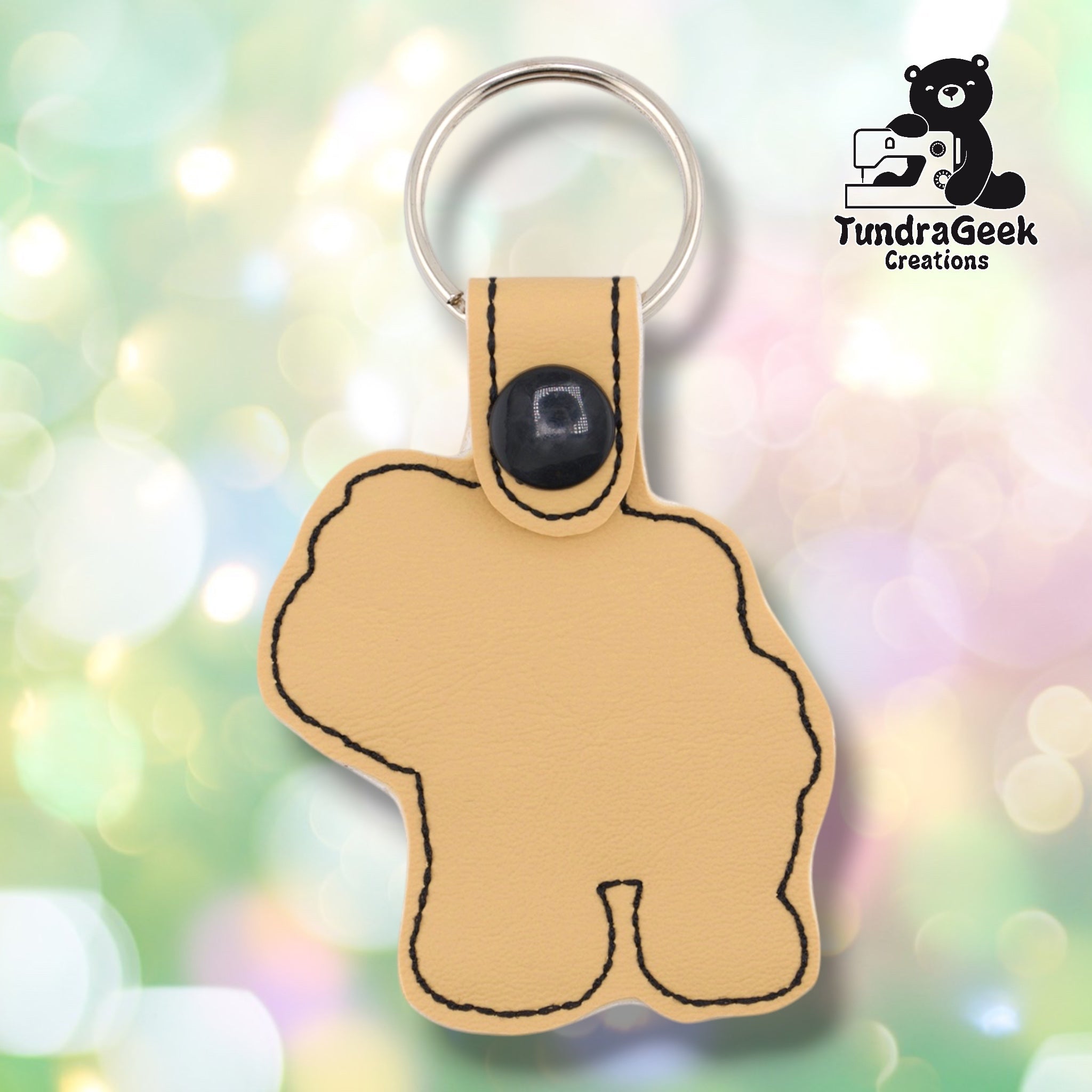 Plain back of the Shih Tzu keychain showing cream faux leather and black outline stitching following the rounded fluffy silhouette. Black snap closure at top. No embroidery on reverse.