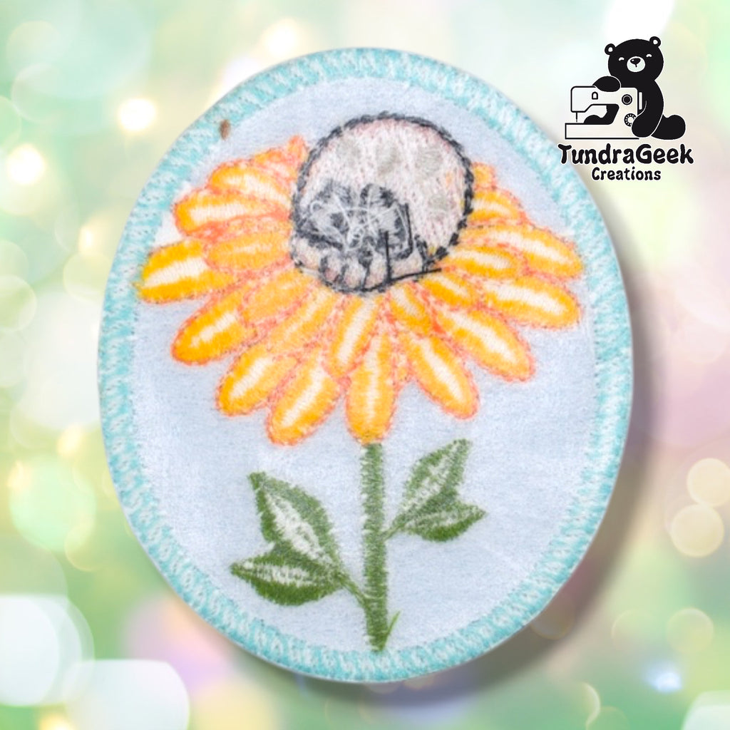 Back of the skull flower patch showing the embroidery backing and light blue fabric with teal border stitching visible through the reverse side.