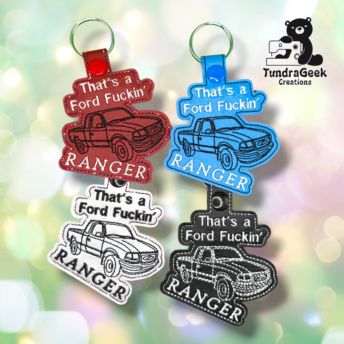 Four keychains shaped like trucks with the text Thats a Ford Fuckin Ranger in various colors, displayed on a blurred green background with the TundraGeek Creations logo.