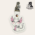 White faux leather keychain featuring a smiling dragon with pink details, metal clasp, and the TundraGeek Creations logo in the top right corner.