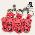 Four red keychains shaped like hands making the rock on gesture are displayed on a light background with the TundraGeek Creations logo in the corner.