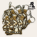 A cluster of embroidered keychains featuring a cartoon bunny design with metal rings and clasps, displayed on a light background. TundraGeek Creations logo is visible in the corner.