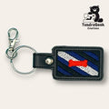 Rectangular keychain with embroidered blue, black, and white stripes and a red bone symbol, attached to a metal clasp and keyring; TundraGeek Creations logo in the corner.