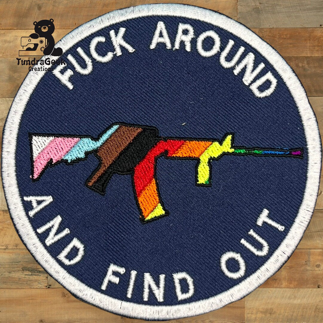 A round patch with a multicolored rifle in the center and the words FUCK AROUND AND FIND OUT embroidered around it.