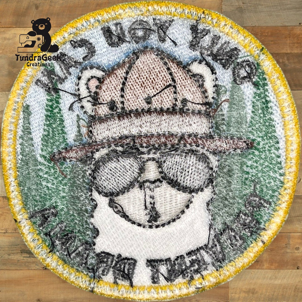 Round embroidered patch featuring a bear wearing a hat and sunglasses, with the words Its not the beard within around the edges. Logo Tundra Geek Creations is in the top left corner.