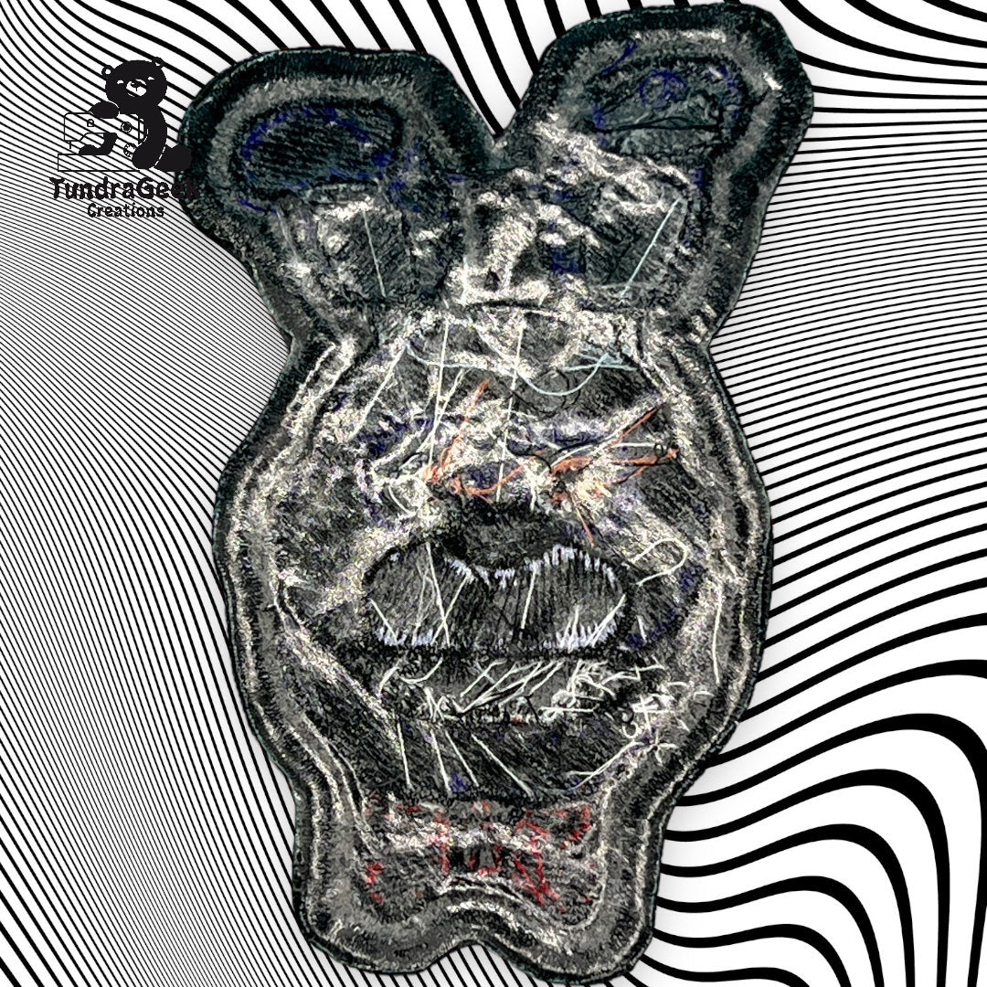 A textured, abstract bear face patch with scribbled details on a black and white wavy striped background, with the TundraGee Creations logo in the top left corner.