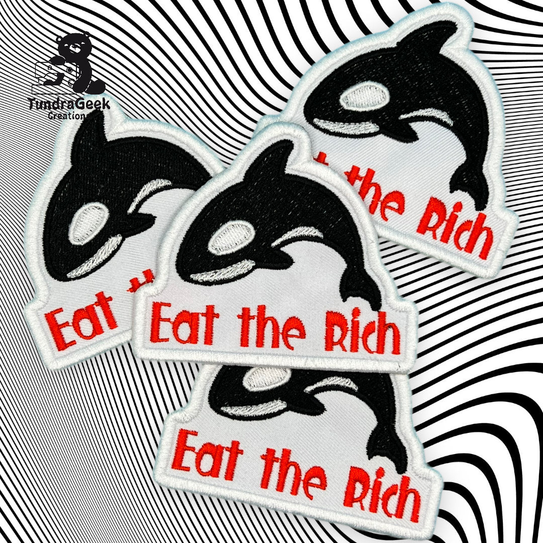 Four embroidered patches featuring an orca and the phrase Eat the Rich in red text, displayed on a black and white wavy background.
