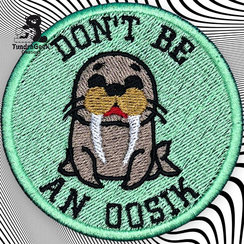 A circular embroidered patch with a cartoon walrus and the text DONT BE AN OOSIK on a green background.