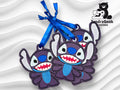 Three fabric ornaments shaped like Stitch from Lilo & Stitch, each with a blue ribbon loop, laying on a wavy white background next to the TundraGeek Creations logo.