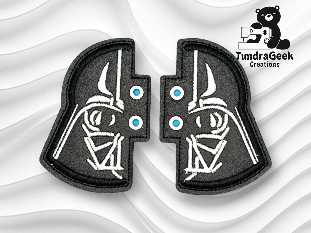 Two black and white embroidered patches form a split Darth Vader helmet design, positioned on a wavy white background with the TundraGeek Creations logo in the top right corner.