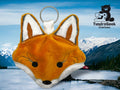 A plush fox face keychain is displayed against a scenic backdrop of a lake and snow-capped mountains, with the TundraGeek Creations logo in the corner.